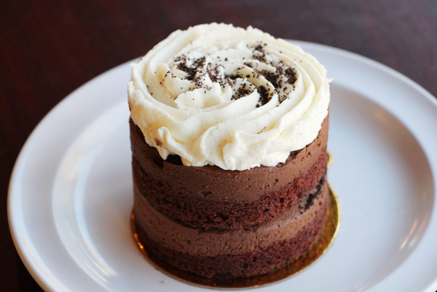 Chocolate mousse cake layered with sponge and topped with whipped cream