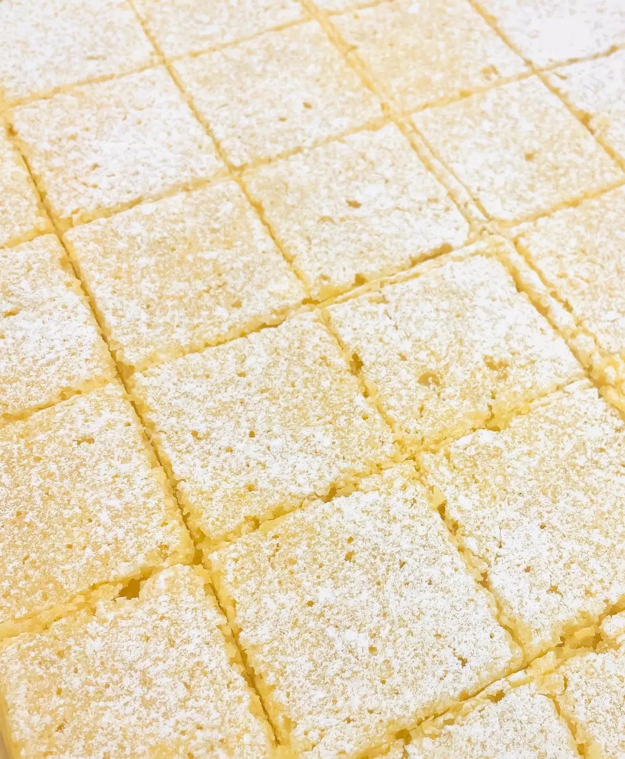 Lemon bars cut into squares and dusted with powdered sugar