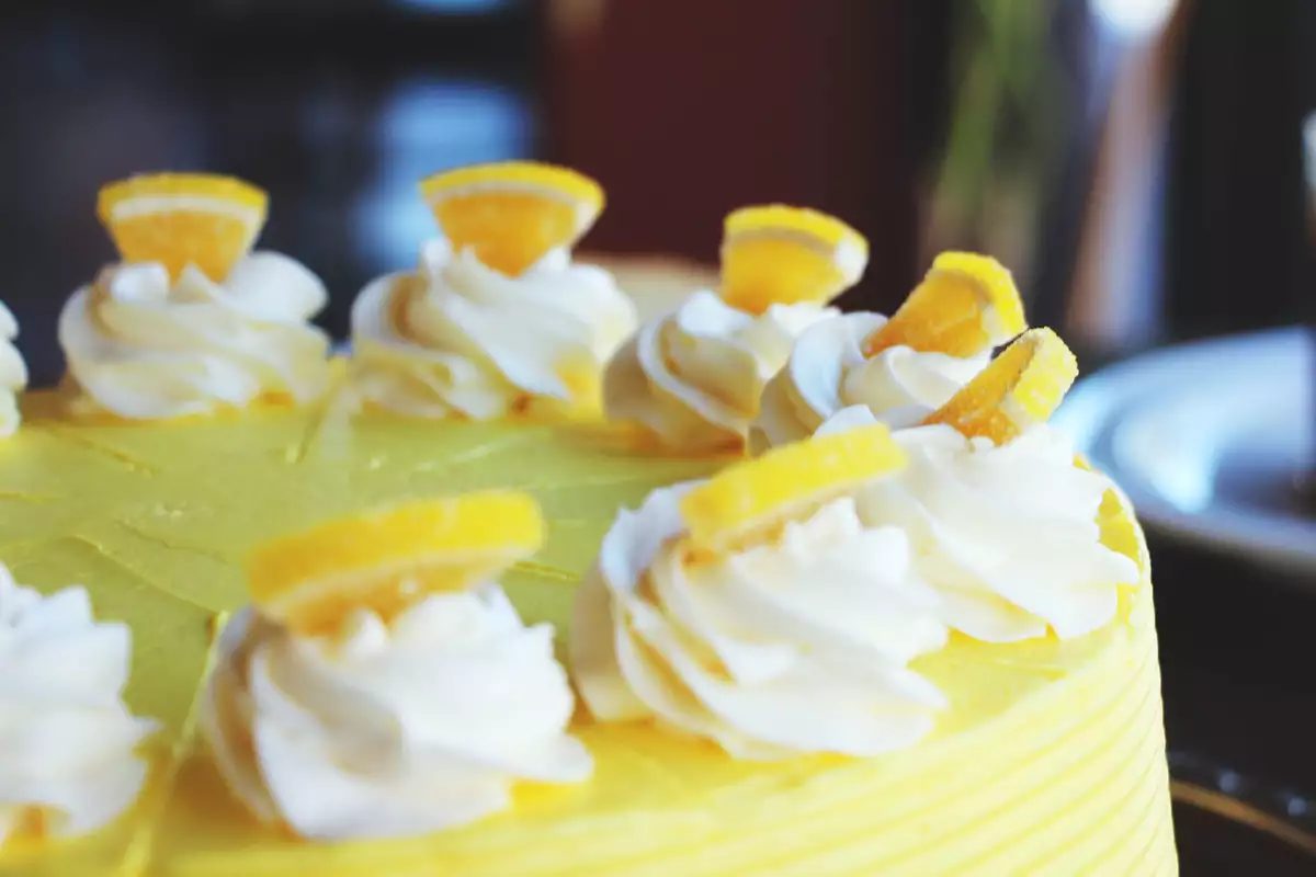 Lemon Dream Cake with piped cream rosettes and candied lemon