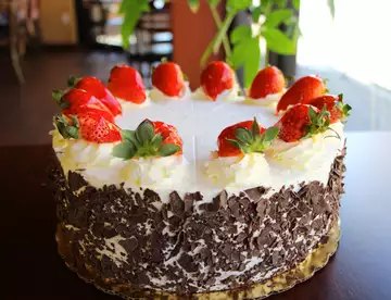 Strawberry black forest cake with chocolate shavings and whole strawberries