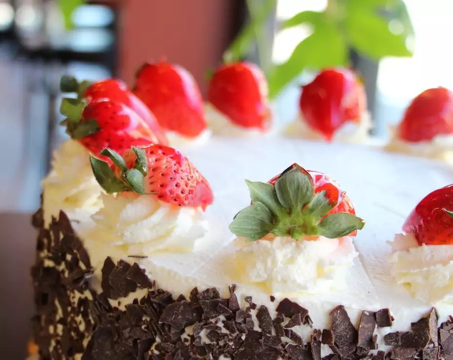 Strawberry Black Forest cake topped with fresh strawberries and chocolate shavings