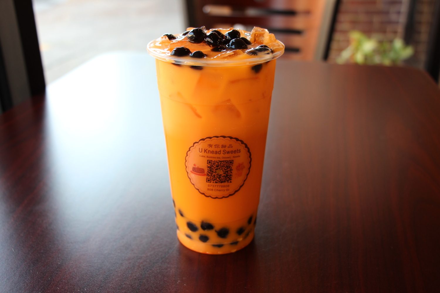 Bright orange Thai tea layered with black tapioca boba
